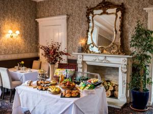 a table with food on it in a room with a fireplace at Kincaid House Hotel in Kirkintilloch