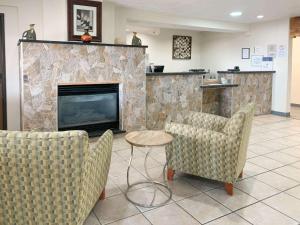 a living room with two chairs and a fireplace at Quality Inn Albuquerque East I-40 Juan Tabo Exit in Albuquerque