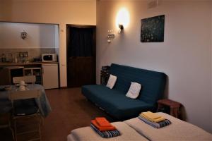 a living room with a blue couch and a kitchen at Petronilla in Fermo