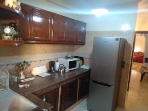 a kitchen with a refrigerator and a microwave at Appartement Bio Meknes Hamria in Meknès