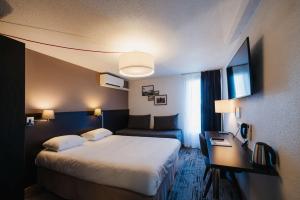 ein Hotelzimmer mit einem großen Bett und einem Schreibtisch in der Unterkunft Sure Hotel by Best Western Châteauroux in Le Poinçonnet + 82 Fotos
