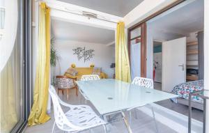 a dining room with a blue table and white chairs at Lovely Apartment In La Grande-Motte in La Grande-Motte +9 photos