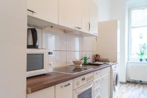 uma cozinha branca com um micro-ondas e um lavatório em Pleasant 3BR Shared Apartment- Ideal for Longstays em Viena