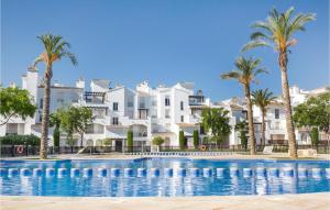 a swimming pool with palm trees and buildings at 2 Bedroom Nice Apartment In Roldán in Los Tomases