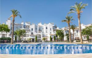 a swimming pool with palm trees and buildings at Awesome Apartment In Roldn With 2 Bedrooms, Wifi And Outdoor Swimming Pool in Los Tomases