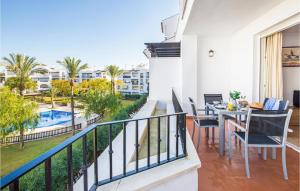a balcony with a table and chairs and a view of a pool at 2 Bedroom Nice Apartment In Roldán in Los Tomases