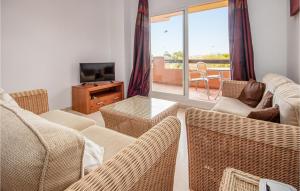 a living room with wicker furniture and a television at Casares Del Sol in Casares