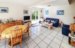 a living room with a table and a blue couch at Stunning Home In Plouguerneau With 3 Bedrooms And Wifi in Plouguerneau