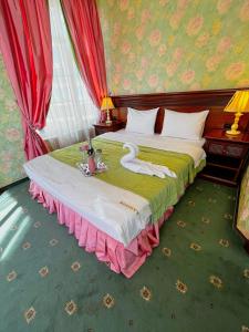 um quarto com uma cama com um cisne em Sunlion Баунти Hotel em Sochi