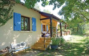 Stunning Home In Snchas With Outdoor Swimming Pool في Charnavas: منزل صغير به مصاريع زرقاء وشرفة