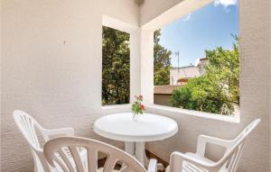 d'une table et de chaises blanches sur un balcon avec fenêtre. dans l'établissement Gorgeous Apartment In Mandre With Kitchen, à Mandre