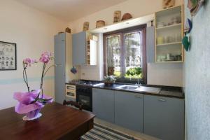 una cocina con una mesa con un jarrón de flores. en Villa Levante vista mare Cornino en Custonaci