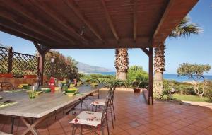 un tavolo e sedie in legno su un patio di Villa Levante vista mare Cornino a Custonaci