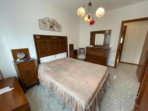 um quarto com uma cama, uma cómoda e um espelho em Follonica, appartamento con 3 camere e doppi servizi. em Follonica