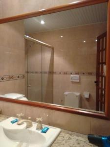 a bathroom with a sink and a large mirror at Magnus Norte Hotel (Adult Only) in Rio de Janeiro