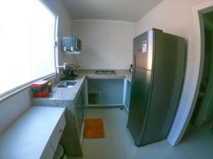 a kitchen with a stainless steel refrigerator and a sink at Ilha Flat Boganville in Abraão