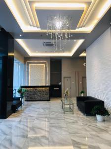 a lobby with a chandelier and a living room at Grand Thamrin Hotel in Jakarta
