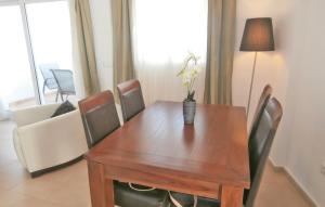 einen Esstisch mit Stühlen und eine Vase mit Blumen darauf in der Unterkunft 2 Bedroom Beautiful Apartment In Sucina in Sucina + 12 Fotos