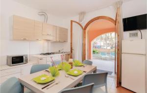 een keuken met een tafel en stoelen en een keuken met een boog bij Marina 3 in Lido di Spina