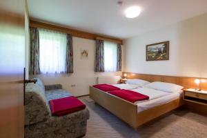 a bedroom with two beds and a couch in it at Apartments Wandaler in St Georgen am Kreischberg in Sankt Georgen ob Murau
