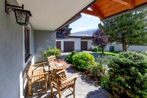 a patio with two wooden chairs and a table at Apartments Wandaler am Kreischberg in Sankt Georgen ob Murau