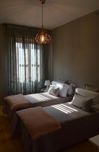 a room with three beds and a chandelier at Omodarme52 in Pisa