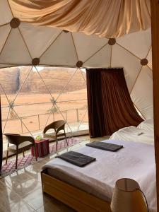 a bedroom with a bed and two chairs in a tent at Bubble RumCamp in Wadi Rum +163 photos