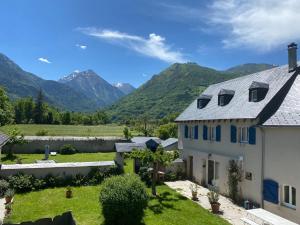 a view of a house with mountains in the background at Chambres d'hôtes Ferme de Gayri in Vielle-Aure +13 photos