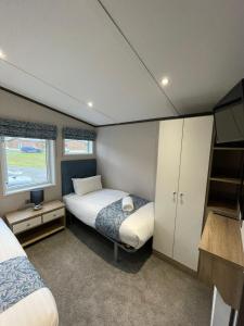a small bedroom with a bed and a tv at Lotus Lodge with Hot Tub in York