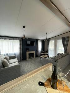 a living room with couches and a table with wine glasses at Lotus Lodge with Hot Tub in York