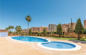 a swimming pool in a park with buildings in the background at Pet Friendly Apartment in Oropesa del Mar