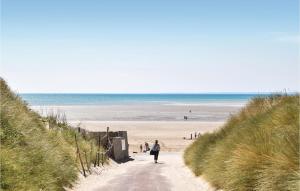 una persona che cammina lungo un sentiero per la spiaggia di Amazing Home In Creances With Wifi a Créances