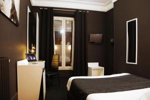 a hotel room with a bed and a laptop on a desk at Hôtel de l'Exposition - République in Paris