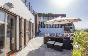 a patio with a table and an umbrella at Amazing Home In Almuñecar in Almuñécar +33 photos