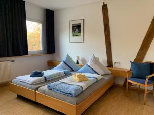 sypialnia z dwoma łóżkami i niebieskimi poduszkami w obiekcie Landgasthaus-Hotel Wenninghoff w mieście Dreierwalde