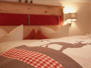 a bed with a blanket with a picture of a deer on it at Pension Alpenblick in Pfronten