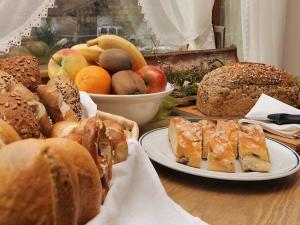 uma mesa coberta com pratos de pão e frutas em Pension Alpenblick em Pfronten