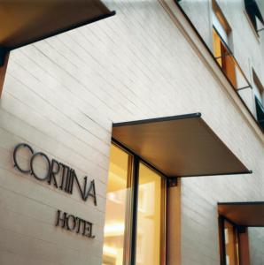 ein Gebäude mit einem Schild für ein Hotel in der Unterkunft CORTIINA Hotel in München