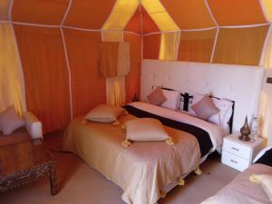 une chambre avec deux lits dans une tente dans l'établissement Luxury Camp & Activities, à Merzouga