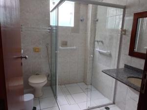 a bathroom with a shower and a toilet and a sink at Pousada Porto do Itagua in Ubatuba +18 photos