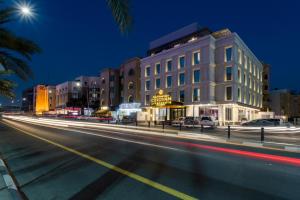 een stadsstraat 's nachts met een gebouw bij Cindyan Apartments by The Quarter in Al Khobar