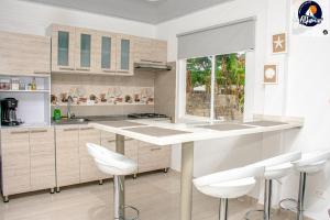 a kitchen with white counters and white stools at APARTAMENTOS TURISTICOS ALTAMAR in San Andrés