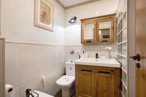 a bathroom with a white toilet and a sink at Piso Chacaras in La Laguna +15 photos