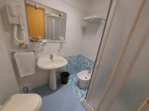 a small bathroom with a sink and a toilet at Hotel Il Gabbiano Beach in Terme Vigliatore