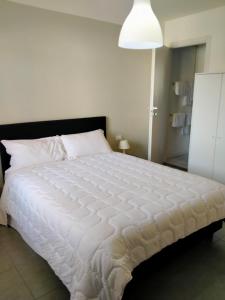 uma grande cama branca num quarto com um candeeiro em Eleonora Bed and breakfast em Muscoline