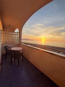 balkon ze stołem i krzesłami oraz widokiem na ocean w obiekcie Hotel Il Gabbiano Beach w mieście Terme Vigliatore