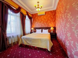 ein Schlafzimmer mit einem Bett in einem Zimmer mit orangefarbenen Wänden in der Unterkunft Sunlion Баунти Hotel in Sochi