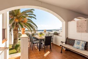 a table and chairs on a balcony with a palm tree at Apartamento Ses Arcades 10 in Son Parc