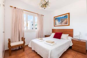 ein Schlafzimmer mit einem Bett und einem Stuhl und einem Fenster in der Unterkunft Apartamento Ses Arcades 10 in Son Parc