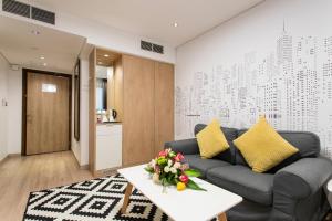een woonkamer met een bank en een tafel bij Cindyan Apartments by The Quarter in Al Khobar